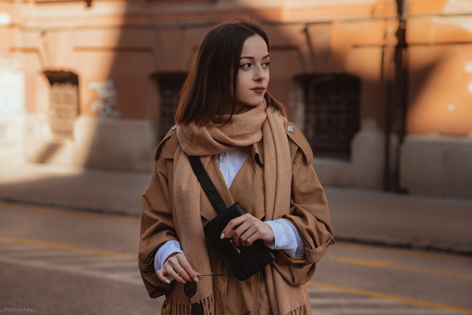 Woman in a brown coat on a city sidewalk in autumn — how to wear brown this fall