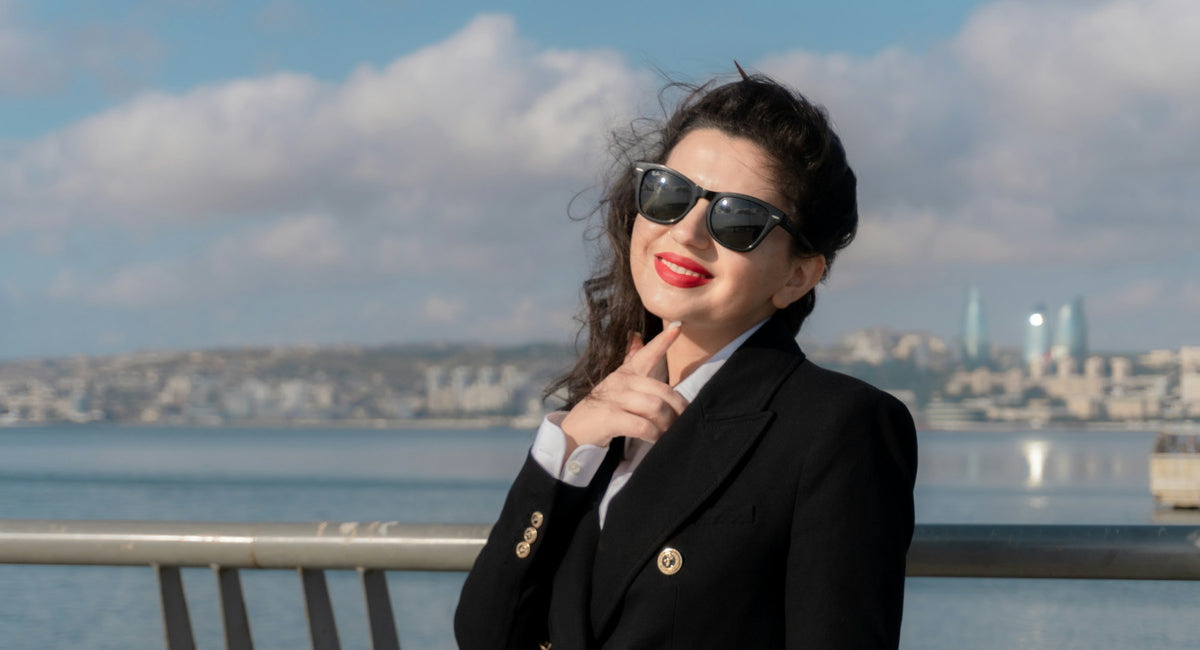 Woman in a tailored black blazer by the water