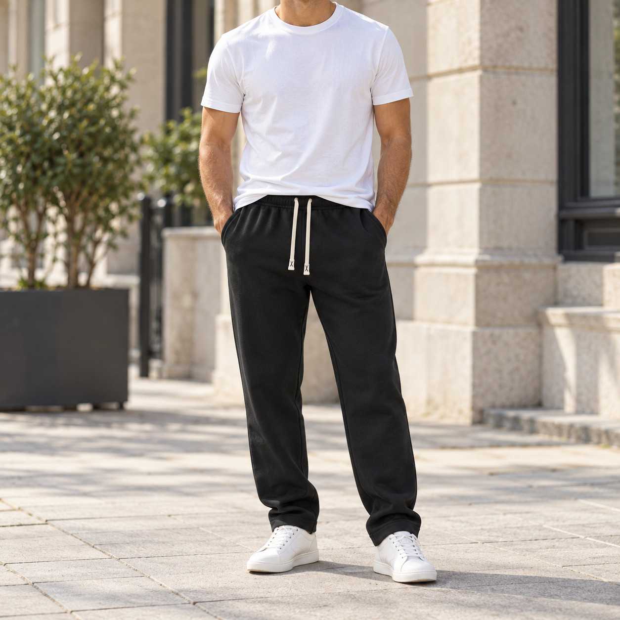 Man wearing the black Toscana fleece-lined straight-leg trousers with a white tee and white sneakers